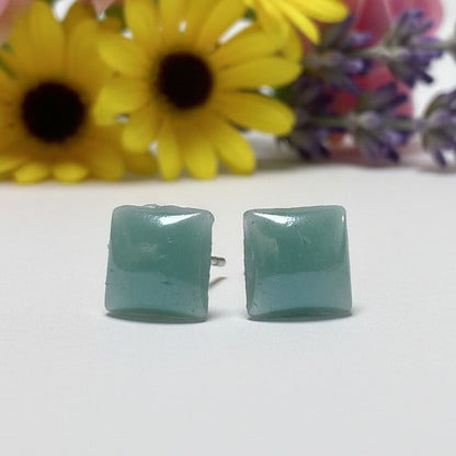 Pair of 8mm handmade square geometric stud earrings crafted from vibrant translucent teal upcycled glass, displaying a smooth finish.