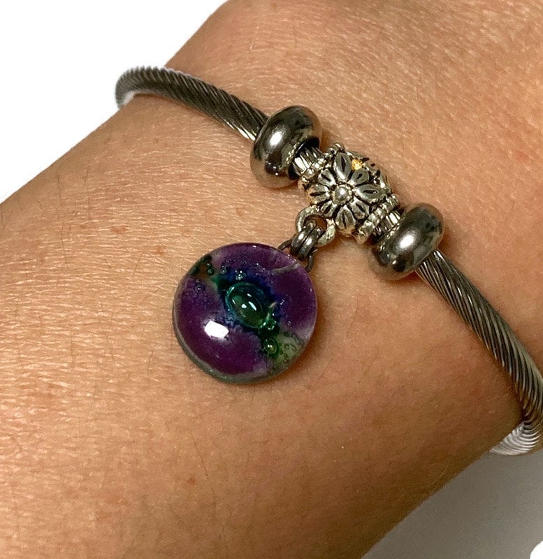 Purple and green Stainless Steel Bracelet Glass Charm Bead. Easy to put on adjustable stretch memory wire. One size fits most