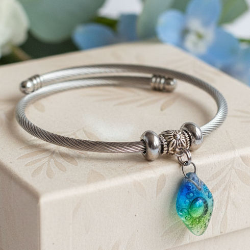 Turquoise, green and blue Stainless Steel Bracelet Glass Charm Bead. Easy to put on adjustable stretch memory wire. One size fits most.