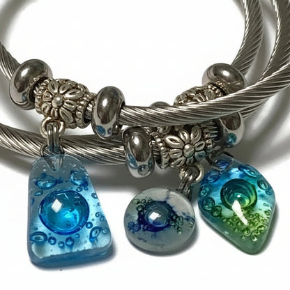 Turquoise, green and blue Stainless Steel Bracelet Glass Charm Bead. Easy to put on adjustable stretch memory wire. One size fits most.